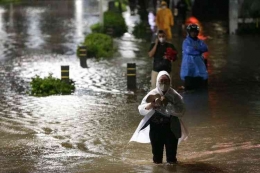Warga melintasi banjir yang mengenang kawasan Kemang, Jakarta Selatan, Kamis (6/10/2022) malam. (KOMPAS.com/KRISTIANTO PURNOMO)