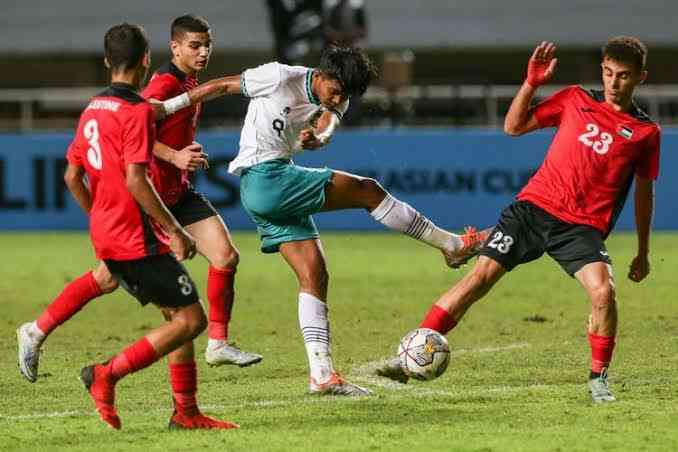 Pemain timnas Indonesia mencoba menendang bola saat dihadang pemain Palestina | (foto: bola.kompas.com)