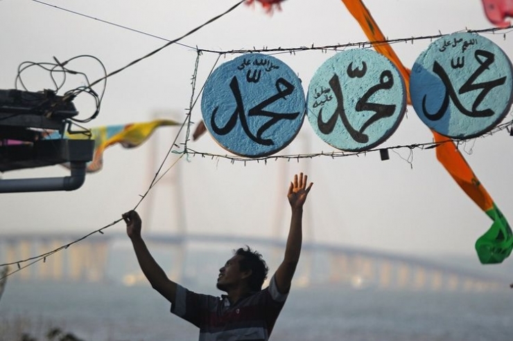 Warga memasang ornamen kaligrafi huruf arab bertuliskan Muhammad di kampung nelayan Nambangan Baru, Surabaya dalam rangka menyambut hari kelahiran atau Maulid Nabi Muhammad SAW.| ANTARA FOTO/Moch Asim/wsj.