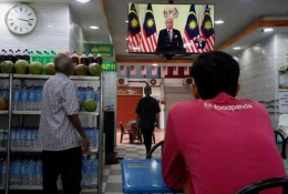 Warga Malaysia menyaksikan berita Perdana Menteri Malaysia  mengumumkan pembubaran parlemen. Photo: benarnews.org