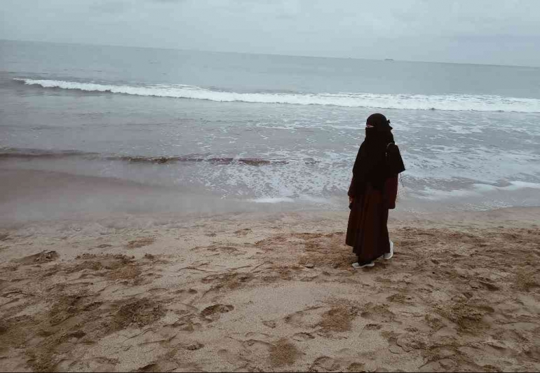 Seorang perempuan sedang menyendiri di Pantai.