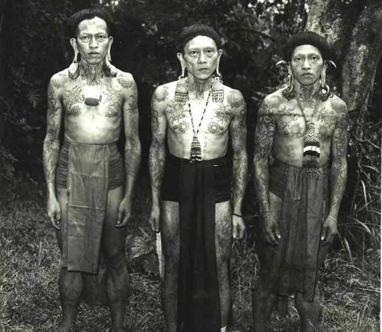 Foto tiga lelaki Dayak dengan tubuh bertato (Sumber: 1001 Indonesia)