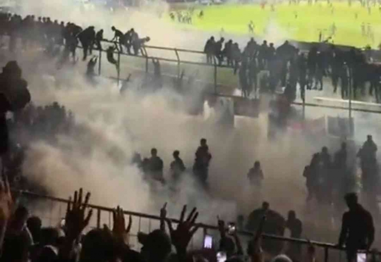 Pendukung Arema FC bergegas menyelamatkan diri di tribun akibat tembakan gas air mata secara masif. (sumber: medcom.id)
