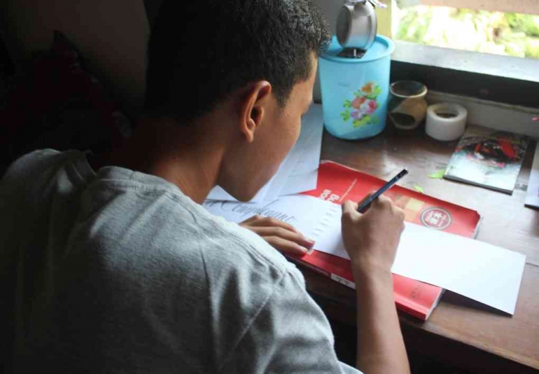 Seorang siswa sedang menyelesaikan pekerjaan rumah (Dokumen Pribadi)