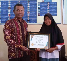 Siswi SMA Negeri 1 Suela, Lombok Timur Diaul Maesaroh memegang piagam juara 3 lomba essai tingkat kabupaten bersama Kepala Sekolah SMA Negeri 1 Suela 