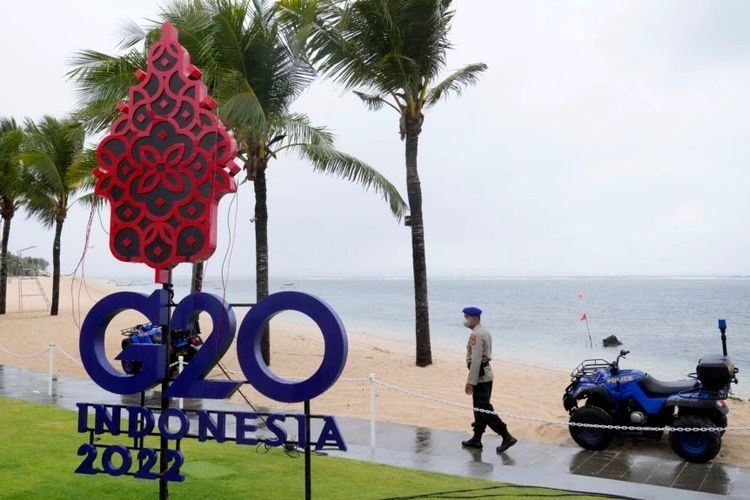Seorang polisi berjalan melewati tanda G20 di Nusa Dua, Bali, 7 Juli 2022.(AP/DITA ALANGKARA via VOA INDONESIA)