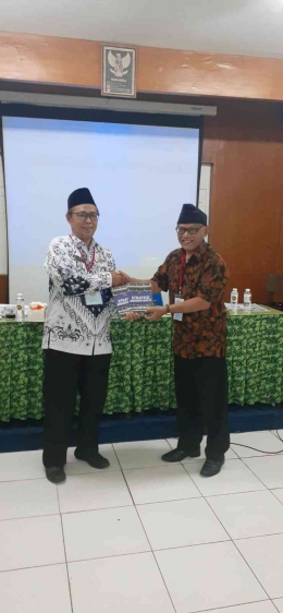 Penulis menyerahkan buku kepada Ketua PGRI Kecamatan Kebayoran Lama (Foto: Dokumentasi PGRI)