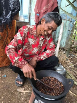 Pak Ru sedang menyangrai kopi yang ia tanam sendiri di kebunnya (Dokumentasi Pribadi)