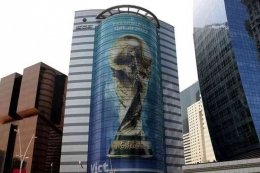 Gambar trofi Piala Dunia Qatar 2022 terpasang di sebuah gedung di Doha, Qatar, pada 16 Agustus 2022. (AFP/MUSTAFA ABUMUNES via VOA INDONESIA)