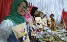 Anggota kelompok kuliner bundo di kawasan Seribu Rumah Gadang Solok Selatan memamerkan kemasan dendeng pucuk ubi. (Riki Chandra/JawaPos.com)