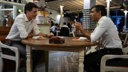 Kala PM Kanada dan PM Inggris bersantai di sebuah kafe di Bali. Mirip kebiasaan turis Eropa ketika di Bali. Sumber: Reuters/Pool/detik.com