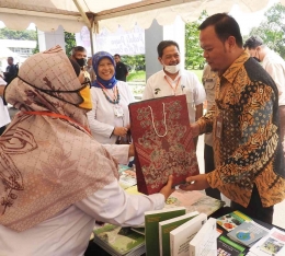 Kepala Bappeda Kota Bogor saat mengunjungi stand pameran PPI  mendapat cinderamata berupa buku-buku dan informasi hasil penelitian (Dok: Kang Bugi)