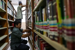 Pustakawan merapihkan tumpukan buku-buku di Perpustakaan Nasional di Jalan Medan Merdeka Selatan, Jakarta Pusat, Rabu (8/11/2017)(KOMPAS.com/GARRY ANDREW LOTULUNG)