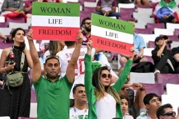 Para supporter Iran membentangkan poster bertuliskan 