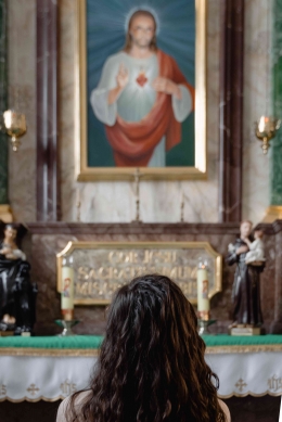Ilustrasi seorang perempuan yang sedang berdoa dan mengaku dosa. Sumber: Pexels / MART PRODUCTION