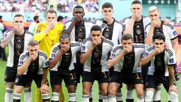 Para pemain Jerman berpose dengan tangan menutupi mulut saat berbaris untuk foto tim sebelum pertandingan Piala Dunia melawan Jepang. (Alexander Hassenstein/Getty Images via CNN)