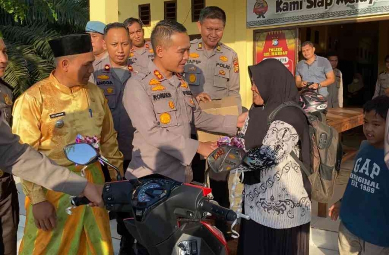 Seorang honorer bernama Suryati (kanan) saat mendapat hadiah sepeda motor dari Kapolres Siak AKBP Roland Sumaja. Foto: Polres Siak for Sofiah.