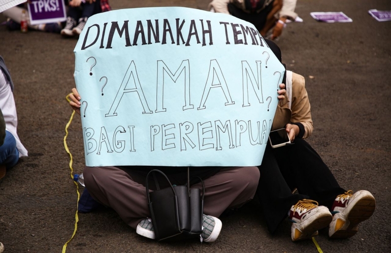 Perempuan  aktivis membentanngkan poster protes saat aksi memperingati Hari Ibu di depan Gedung MPR/DPR/DPD, Jakarta Pusat, Rabu (22/12/2021). Mereka menuntut pengesahan RUU TPKS. Foto: Kompas/Priyombodo