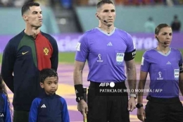Pertandingan Grup H, Ronaldo di lapangan dengan didampingi anak Indonesia bernama Ulul Albab El Ibrahim.(PATRICIA DE MELO MOREIRA/AFP) via kompas.com