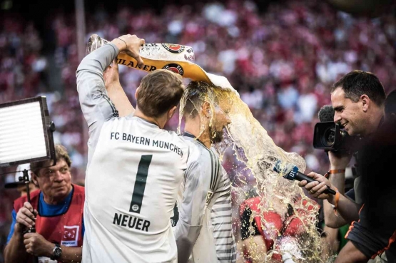 Neuer selebrasi dengan mengucurkan bir ke pemain lain usai menjuarai Bundesliga. Sumber: Maja Hitij / Bundesliga/ Getty Images/ www.bavarianfootballworks.com