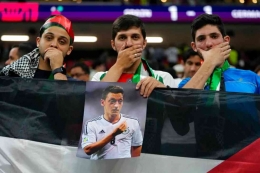 Para penonton  di pertandingan Jerman melawan Spanyol yang menutup mulutnya sebagai sindiran terhadap Jerman atas perlakuan rasisme terhadap Ozil. Photo: Julio Cortez/AP .
