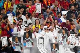 Dukungan terhadap Ozil atas perlakuan rasisme oleh penonton pertandingan Jerman melawan Spanyol dengan cara menutup mulut dan membawa photo Ozil. Photo: Matthias Schrader/AP  
