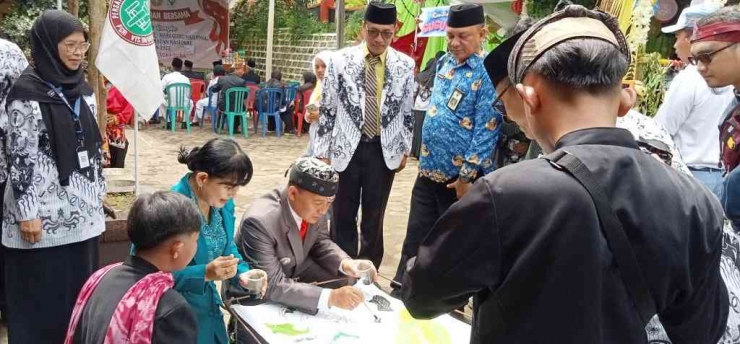 Bapak dan Ibu Camat Sukapura didampingi Ketua PGRI Cabang Sukapura sedang mencanting di stan bazar SMPN 1 Sukapura.| Sumber: Dokumentasi Pribadi