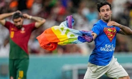 Tampak seorang suporter membawa bendera pelangi memasuki lapangan ketika pertandingan Portugal vs Uruguay (ukdaily.news/Jasoon More)