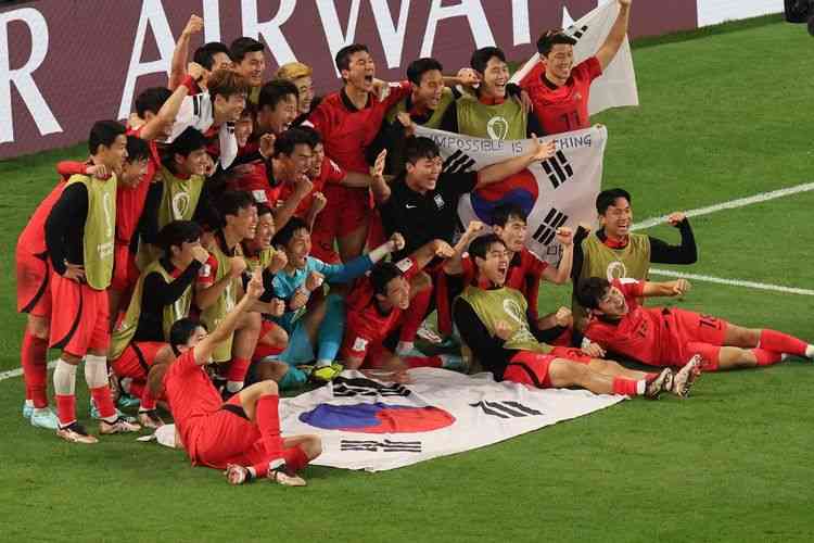 Skuad Korea Selatan merayakan keberhasilan lolos ke babak 16 besar Piala Dunia 2022. (Foto: AFP/JACK GUEZ)