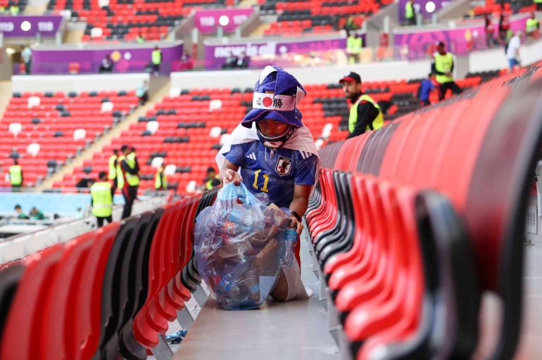 Tampak salah satu penonton asal Jepang yang sedang memungut sampah di tribun (sumber: twitter/FIFAcom)