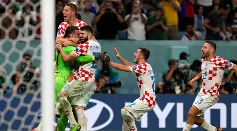 KIper Dominik Livakovic diburu rekan-rekannya setelah menjadi pahlawan kemenangan Kroasia atas Jepang (Foto: AP Photo via indianexpress.com)