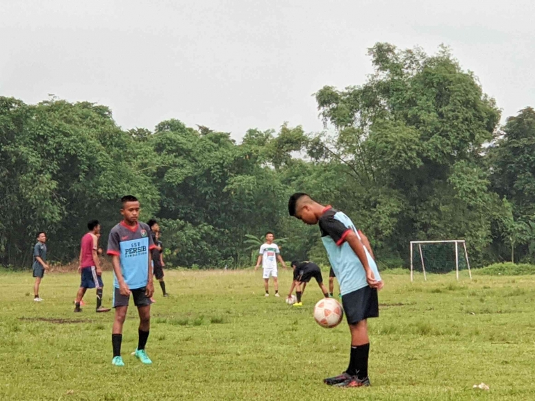 Hafiz (19) bersama kawan-kawannya sedang latihan sepak bola di Lapangan Bondoyudo Minggu sore (04/12/2022).