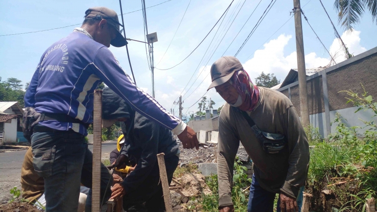 Sekelompok tukang sedang memperbaiki jalan, meskipun dibawah terik matahari mereka tetap bekerja, Rabu (07/12/2022) 