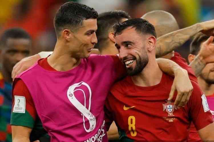 Cristiano Ronaldo (kiri) berbincang dengan Bruno Fernandes (kanan) pada laga Piala Dunia 2022 Portugal vs Uruguay. (AFP/ ODD ANDERSEN via Kompas.com)