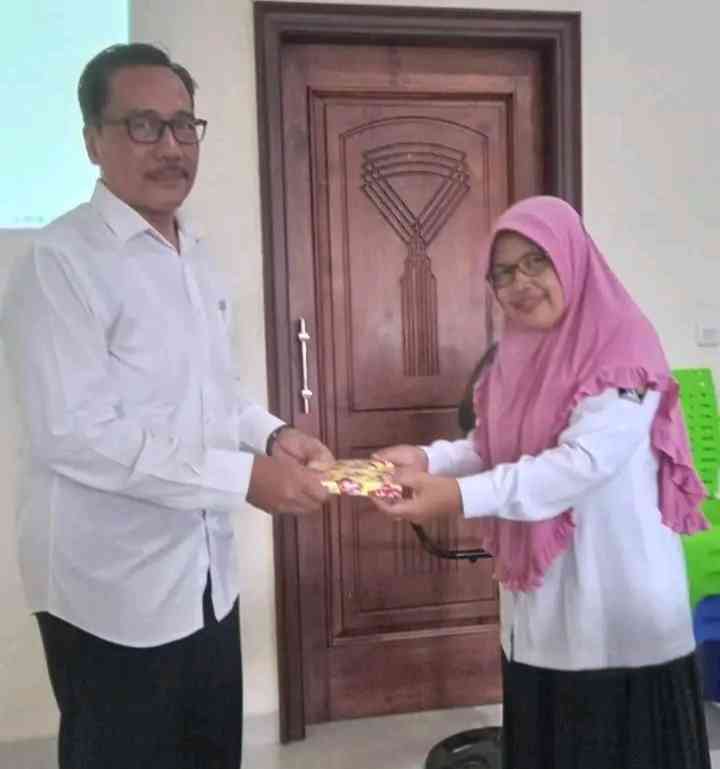 Nurhabib ketika menyerahkan souvenir pada salah satu guru | Foto: Siti Nazarotin 