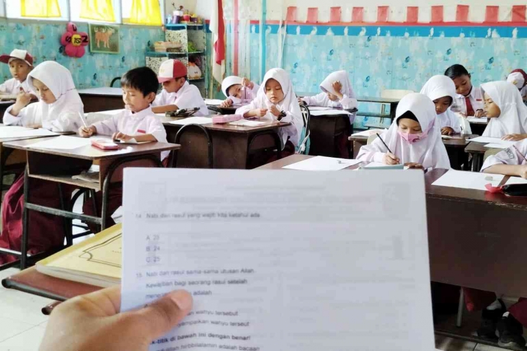 Ketika guru membacakan soal ujian bagi siswa Kelas 1 SD (foto Akbar Pitopang)