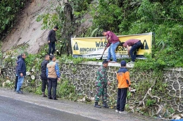 Dok Makodim 0205/Tanah Karo 13122022 Pemasangan Spanduk bahaya bencana dan pembesihan ranting roboh ke selokan maupun jalan