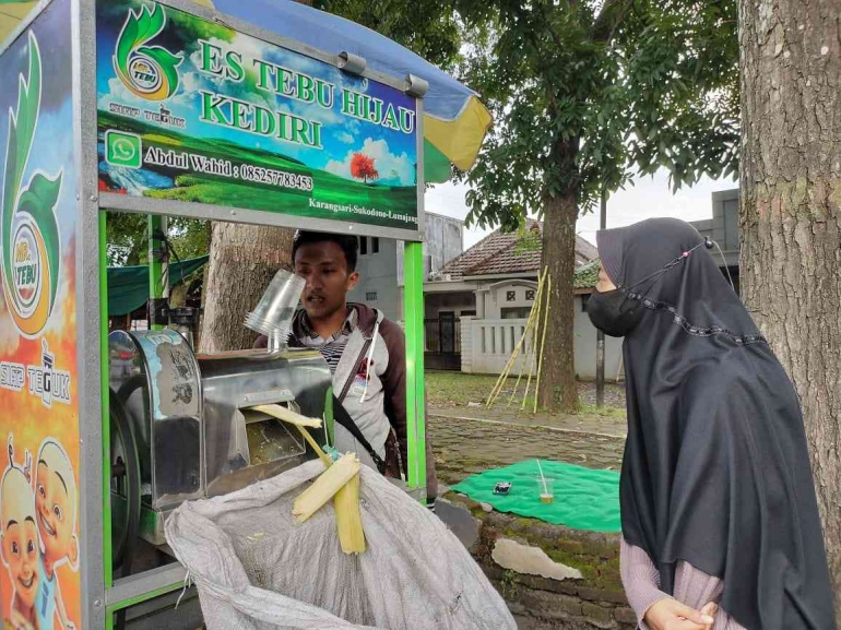Pembeli:Seorang Mahasiswi sedang membeli Es Tebu Kediri di depan Taman Hutan Kota Toga-Lumajang. (Potret:Hilwatul F. Mahasiswi KPI-IAIS Lumajang)