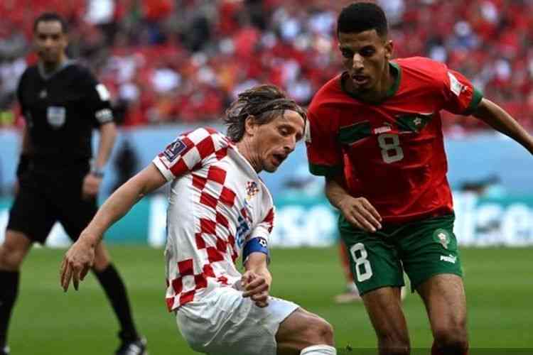 Luka Modric (kiri) berebut bola dengan pemain Maroko, Azzedine Ounahi di fase Grup F Piala Dunia 2022: AFP/OZAN KOSE via Kompas.com