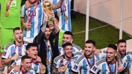  Lionel Messi dan rekan satu timnya merayakan dengan trofi Piala Dunia. (Robert Michael/dpa)