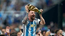 Lionel Messi dengan senyuman lebar mengangkat trofi Piala Dunia 2022. (Foto: Getty Images/Quality Sport Images)