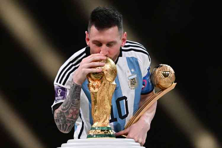 Kapten Argentina Lionel Messi mencium Trofi Piala Dunia FIFA setelah memenangkan pertandingan final Piala Dunia 2022 Qatar antara Argentina vs Prancis di Stadion Lusail, Doha pada Minggu 18 Desember 2022. (AFP/ KIRILL KUDRYAVTSEV via kompas.com)