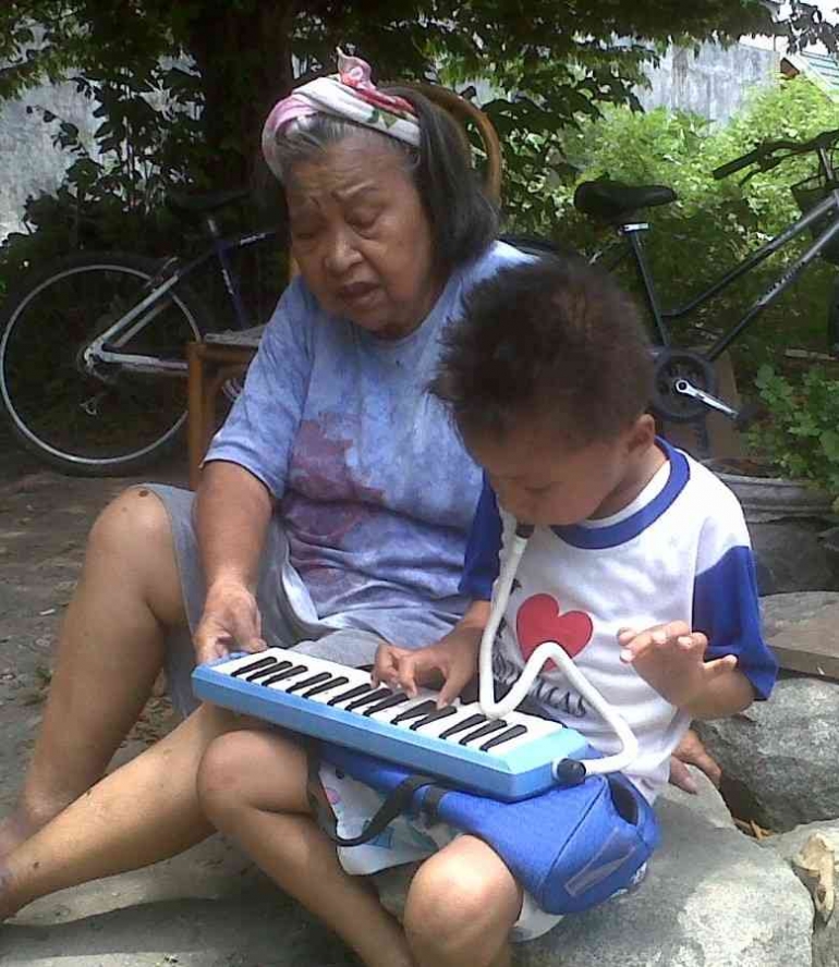 Ibu melatih Niel bermain pianika
