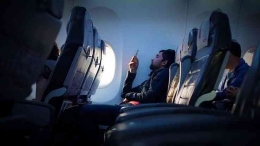 Foto ilustrasi penumpang menggunakan smartphone di dalam pesawat | (foto: euronews.com)
