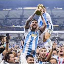 Lionel Messi mengangkat Trophy Piala Dunia 2022 (foto:dpa/picture alliance via Getty I.)