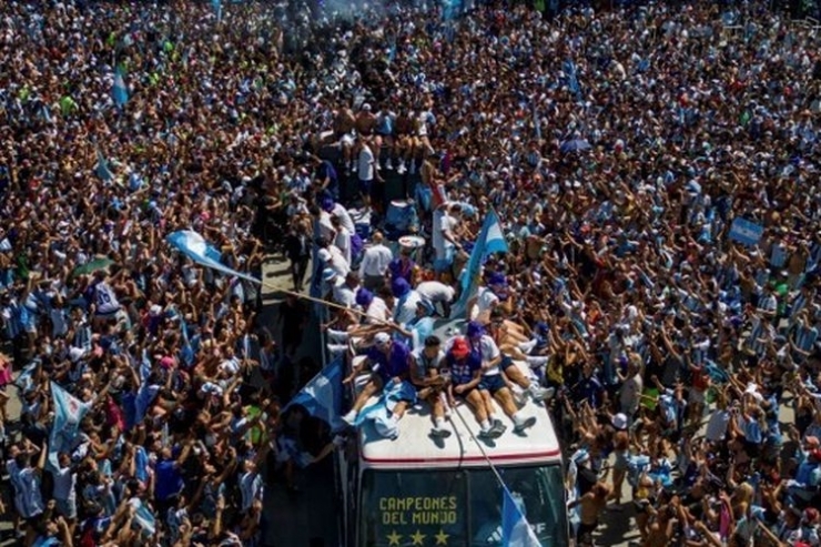 Pemain timnas Argentina menyapa para fans yang turun ke jalanan Buenos Aires dari atas bus terbuka untuk merayakan keberhasilan meraih gelar juara Piala Dunia 2022, Selasa (20/12/2022). Foto: AFP/Tomas Cuesta