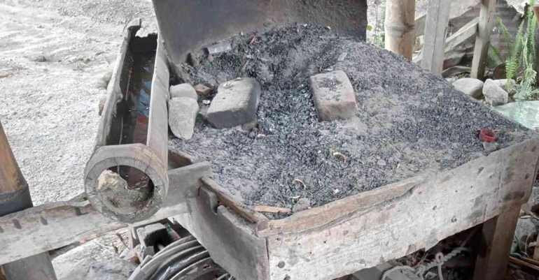 Palungan dari bambu yang berisi air, digunakan dalam proses penyepuhan logam di bengkel pandai besi (Dok. Pribadi)