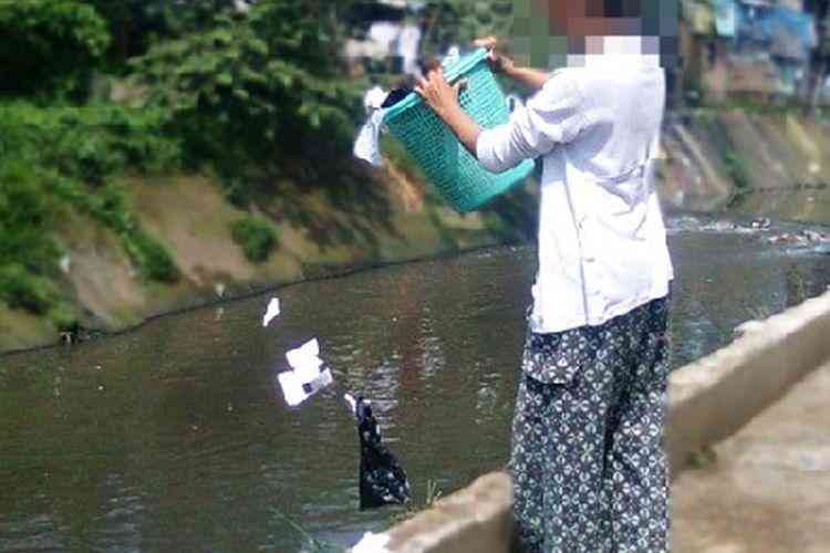 Gambar 4. Seseorang membuang sampah di sungai/goriau.com