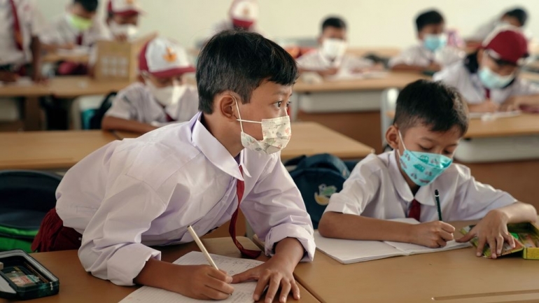 Pelajar mencatat dalam pembelajaran tatap muka (PTM) di SDN Klender 01, Jakarta Timur, Selasa (4/1/2022) | KOMPAS/AGUS SUSANTO 