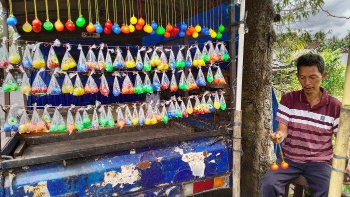 Penjual lato-lato, Antar Margono (55) saat berjualan di sekitar Cebongan, Sleman, Selasa (03/01/2023).| TRIBUNJOGJA.COM/Christi Mahatma
